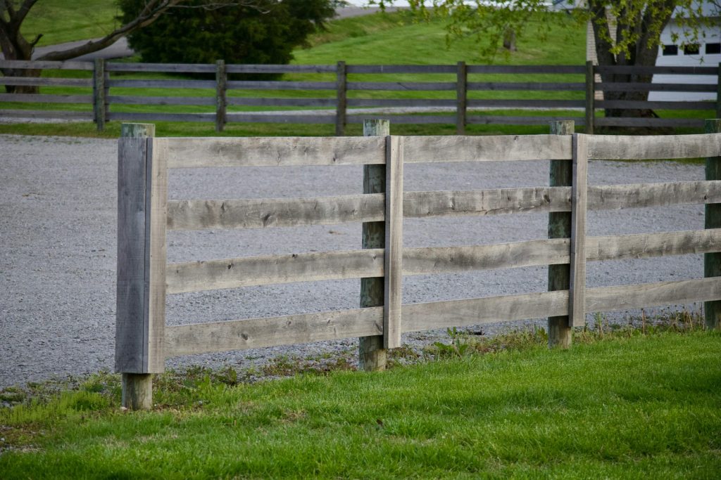 Wooden fences border a grassy area.